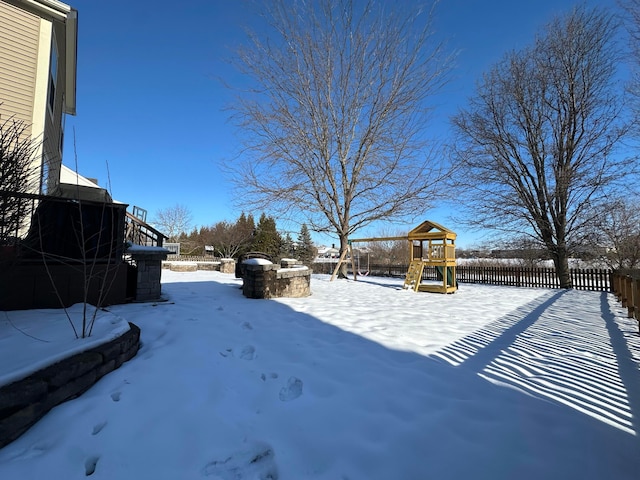 yard layered in snow featuring a playground