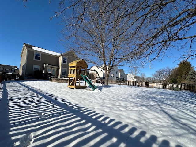 yard layered in snow with a playground