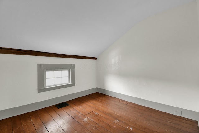 spare room with hardwood / wood-style floors and vaulted ceiling