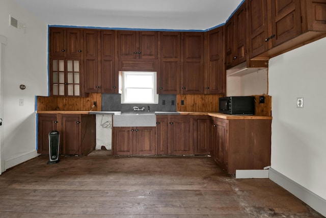 kitchen featuring decorative backsplash and dark wood-type flooring