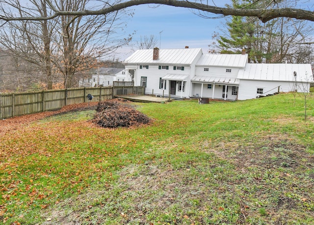 rear view of property featuring a yard and a deck