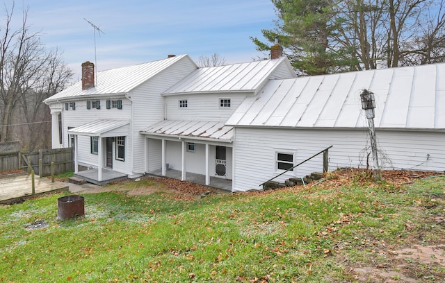 rear view of property featuring a lawn