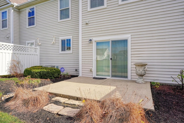 view of exterior entry with a patio area