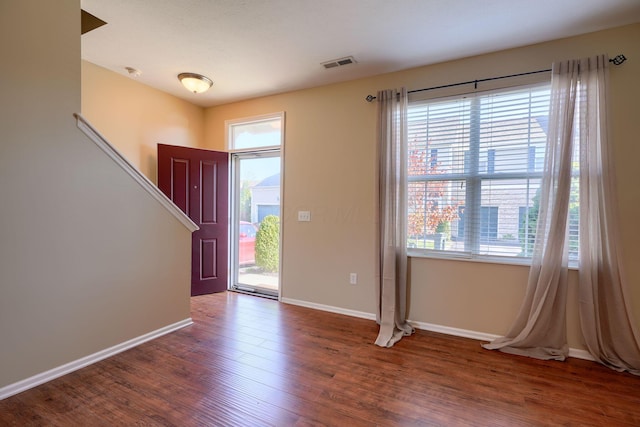 foyer entrance with dark hardwood / wood-style floors and a healthy amount of sunlight