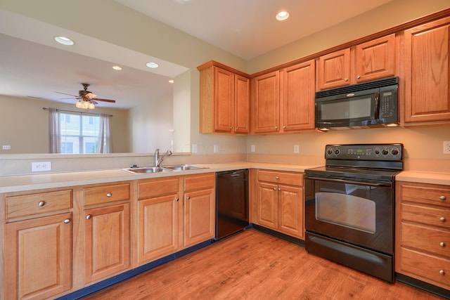 kitchen featuring black appliances, sink, light hardwood / wood-style flooring, ceiling fan, and kitchen peninsula