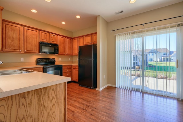 kitchen featuring sink, light hardwood / wood-style flooring, and black appliances