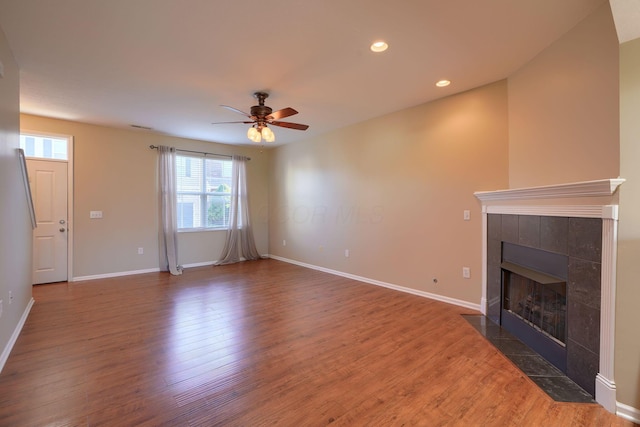 unfurnished living room with a fireplace, dark hardwood / wood-style flooring, and ceiling fan