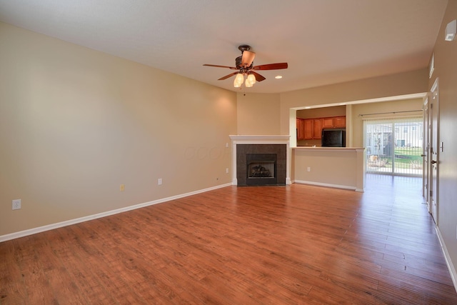 unfurnished living room featuring ceiling fan, light wood-type flooring, and a fireplace