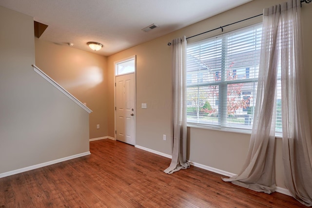 entrance foyer with hardwood / wood-style floors, a textured ceiling, and a wealth of natural light