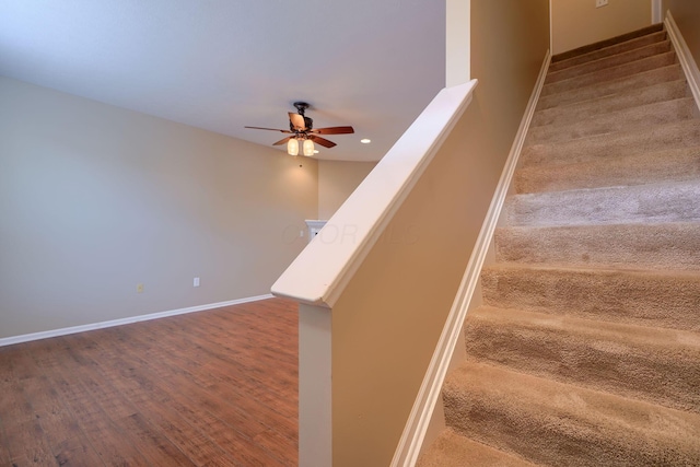 stairway featuring hardwood / wood-style flooring and ceiling fan