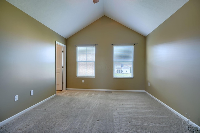 carpeted empty room featuring vaulted ceiling