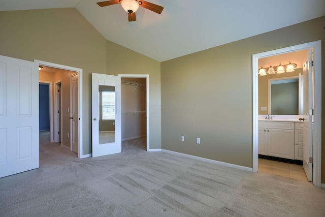 unfurnished bedroom with ensuite bathroom, light colored carpet, ceiling fan, a spacious closet, and a closet