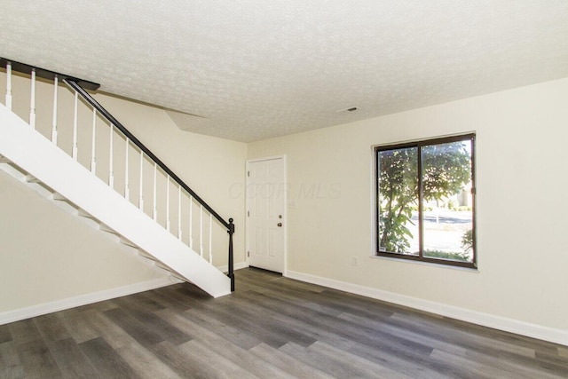 interior space with dark hardwood / wood-style floors and a textured ceiling