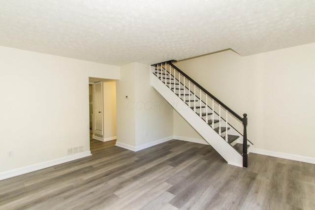 interior space featuring dark hardwood / wood-style flooring and a textured ceiling