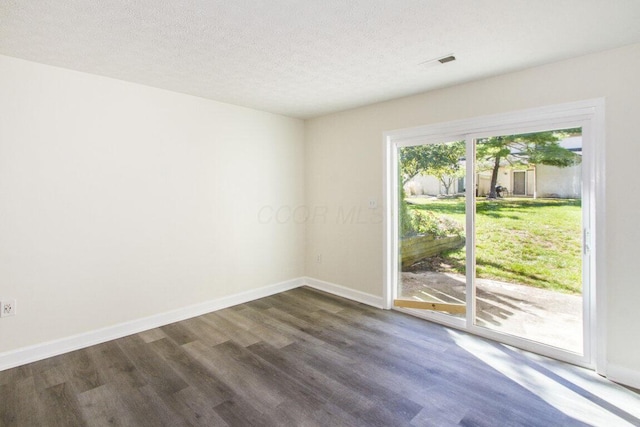 spare room with a textured ceiling and dark wood-type flooring