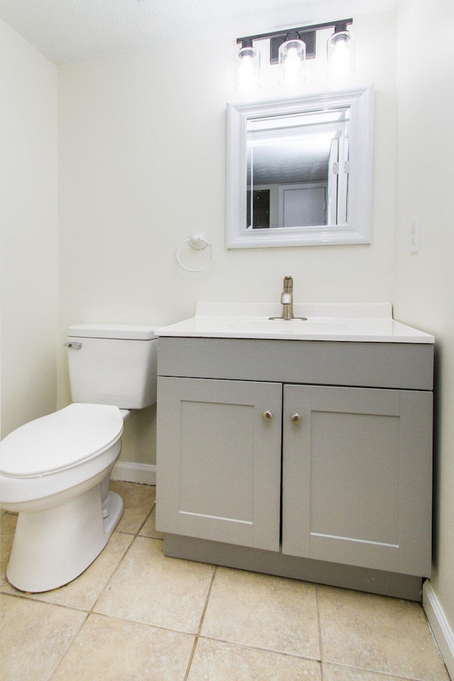 bathroom featuring tile patterned floors, vanity, and toilet