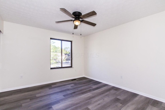 empty room with dark hardwood / wood-style floors, ceiling fan, and a textured ceiling