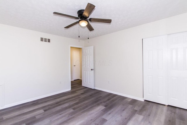 unfurnished bedroom featuring ceiling fan, a closet, and dark hardwood / wood-style floors