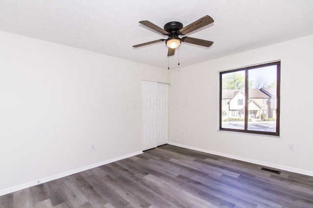 unfurnished room with dark hardwood / wood-style floors, ceiling fan, and a textured ceiling