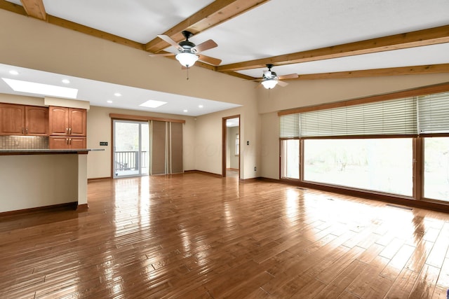 unfurnished living room with wood-type flooring, lofted ceiling with beams, and ceiling fan