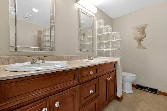 bathroom with tile patterned flooring, vanity, and toilet