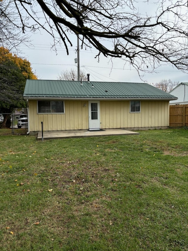 rear view of house with a lawn and a patio area