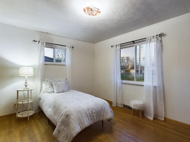 bedroom featuring dark hardwood / wood-style floors and a textured ceiling