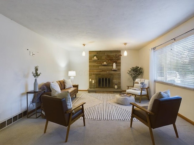 living room with carpet and a stone fireplace