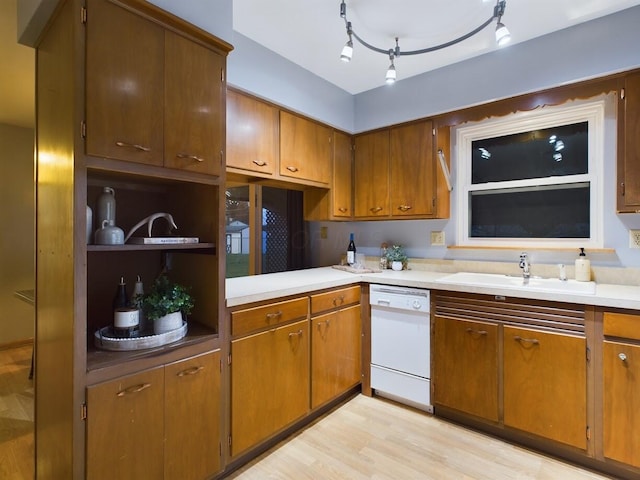 kitchen with dishwasher, sink, and light hardwood / wood-style floors