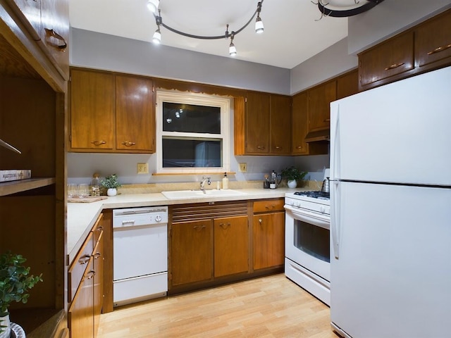 kitchen with sink, white appliances, and light hardwood / wood-style floors