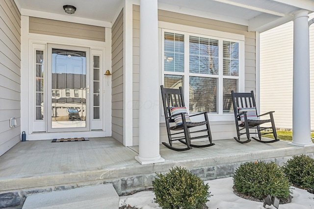 view of exterior entry featuring covered porch