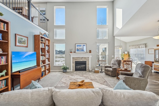 living room with a towering ceiling and a stone fireplace