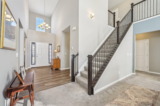 carpeted entrance foyer featuring a towering ceiling and a chandelier