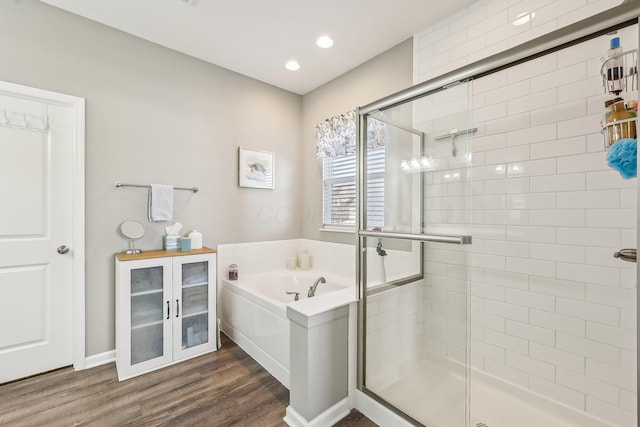 bathroom featuring hardwood / wood-style flooring and separate shower and tub