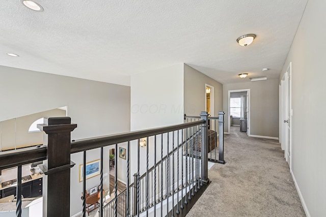 hall with carpet flooring and a textured ceiling