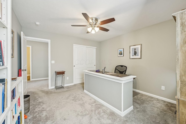 carpeted office space with ceiling fan