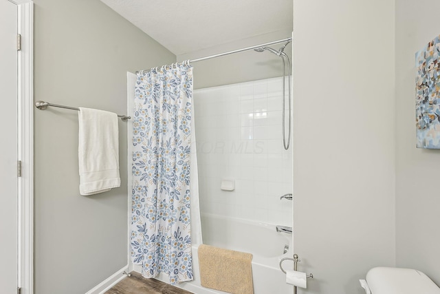 bathroom featuring shower / tub combo, hardwood / wood-style floors, and toilet