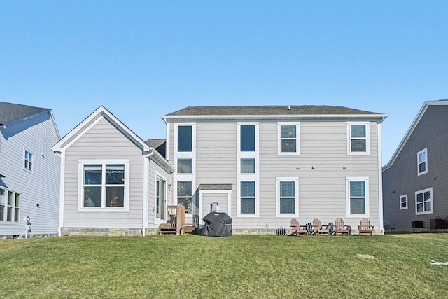 rear view of house with a yard and central AC