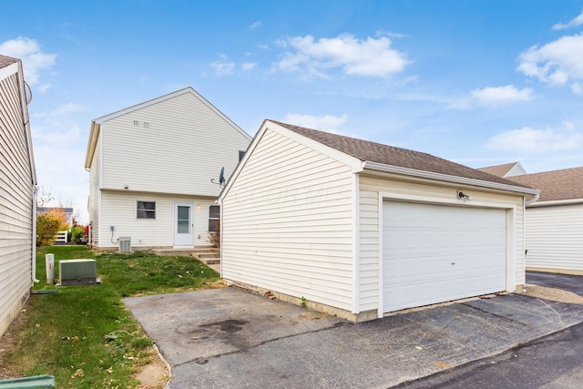 garage with a yard and central AC unit