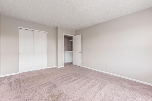 unfurnished bedroom featuring a closet, carpet, and a textured ceiling