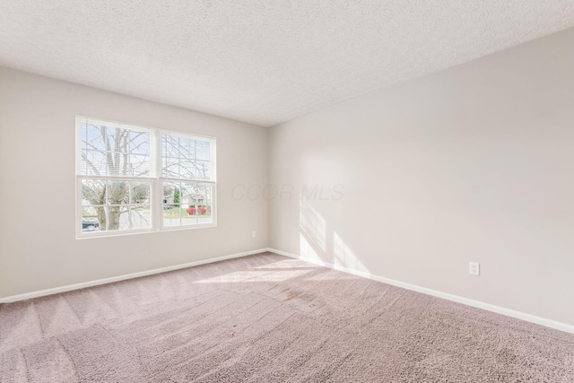 spare room featuring carpet floors and a textured ceiling