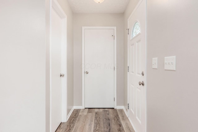 entryway featuring a textured ceiling and light hardwood / wood-style flooring