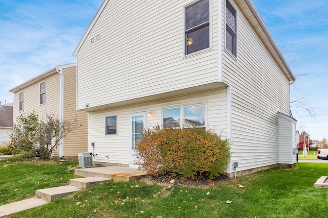 back of house featuring a yard and central AC