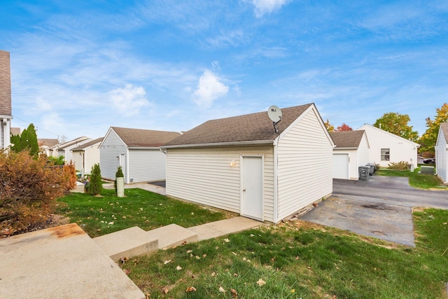 view of side of property with a yard and an outdoor structure