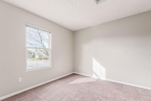 carpeted spare room featuring a textured ceiling