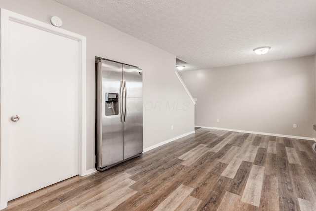 kitchen featuring stainless steel refrigerator with ice dispenser, a textured ceiling, and hardwood / wood-style flooring