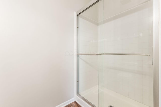 bathroom featuring wood-type flooring and an enclosed shower