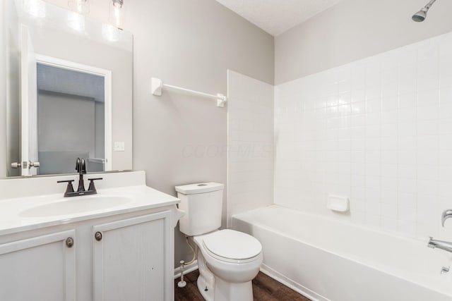 full bathroom featuring vanity, bathing tub / shower combination, hardwood / wood-style flooring, toilet, and a textured ceiling