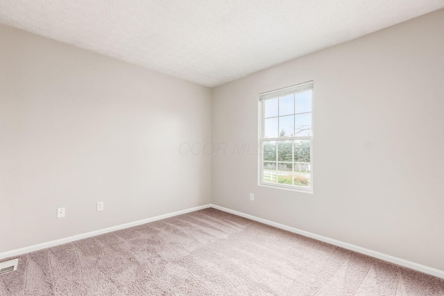 carpeted spare room featuring a textured ceiling