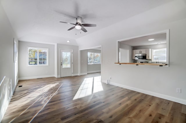 unfurnished living room with ceiling fan, vaulted ceiling, and dark hardwood / wood-style floors